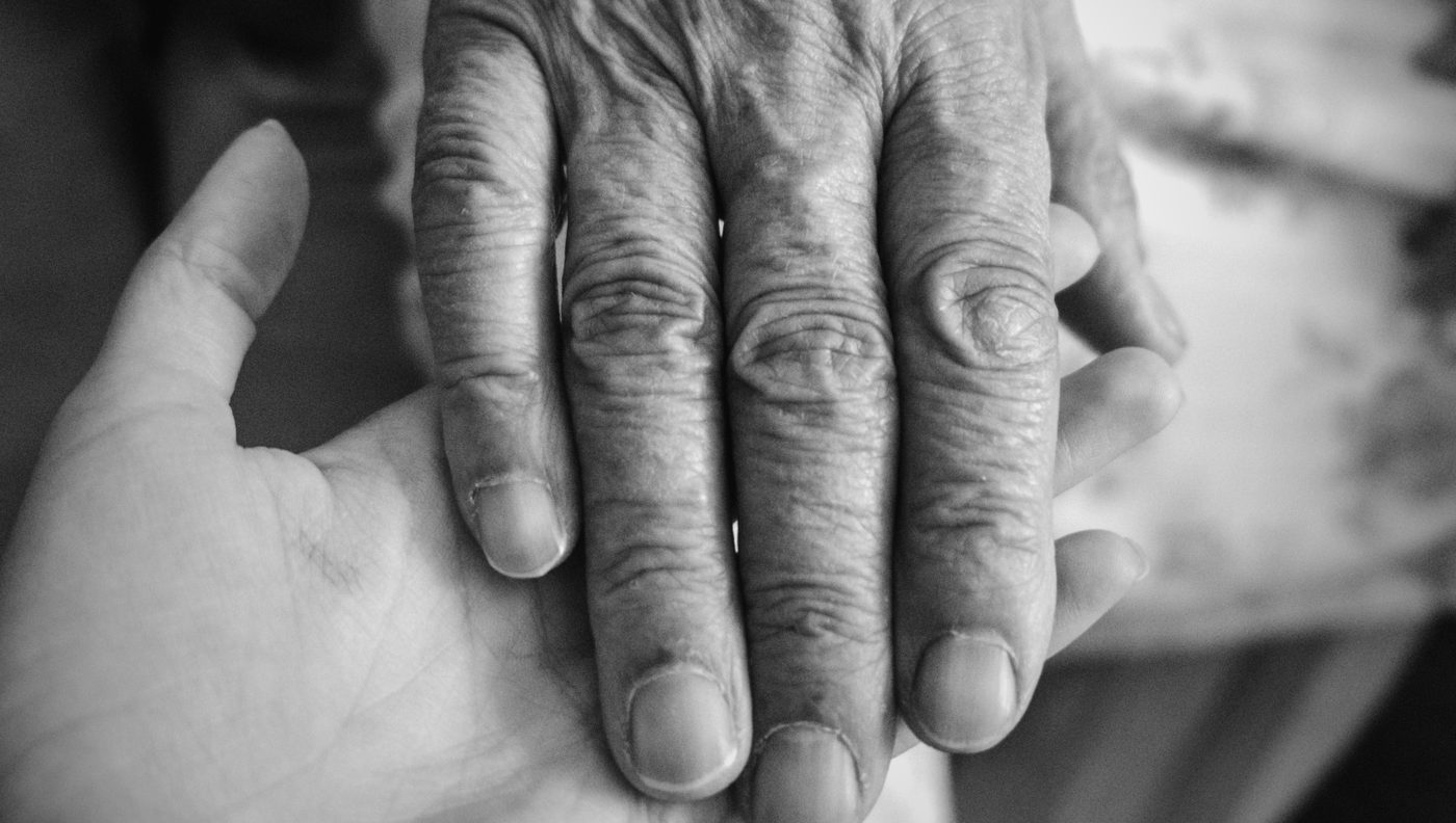 A younger hand holding an older hand