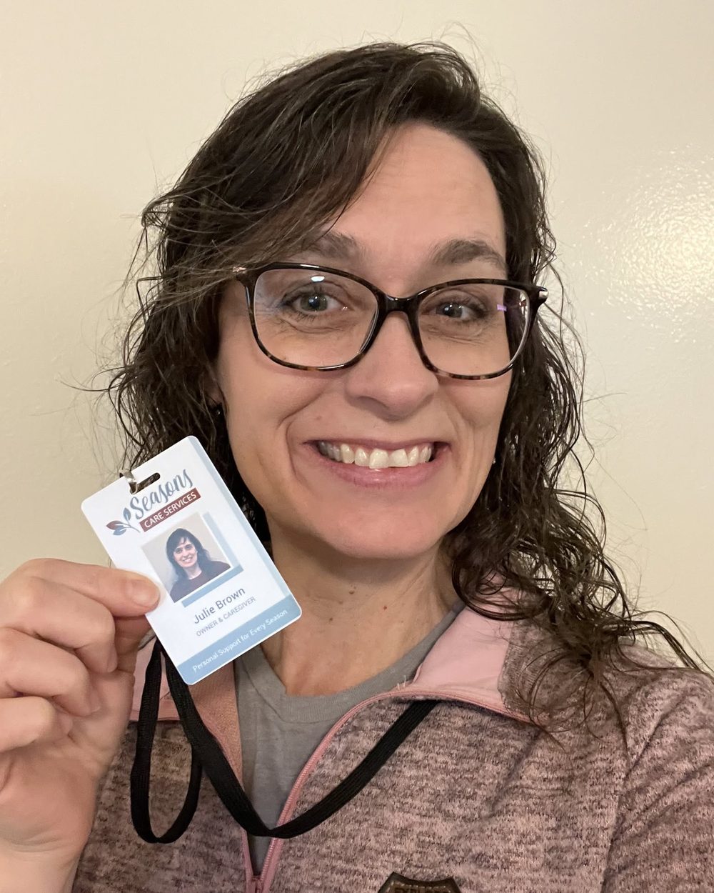 Julie Brown holding her Seasons Care Services identification badge