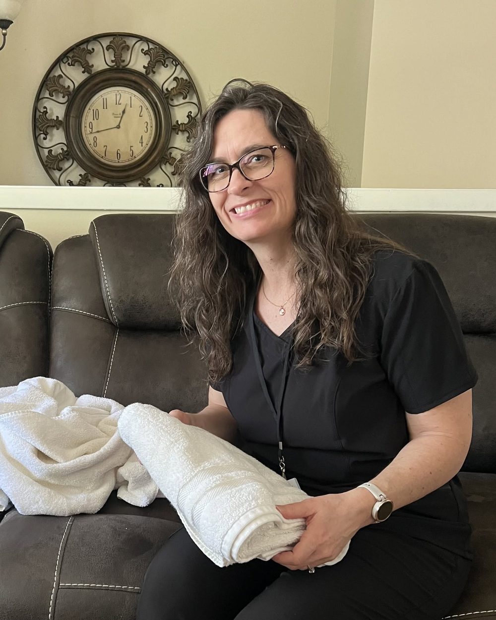 Julie folding fresh laundry in a client's living room